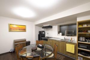 eine Küche mit einem Glastisch in einem Zimmer in der Unterkunft 箱根 -桃源郷- 036h in Hakone