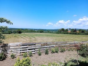a wooden fence in front of a field at La Belle brune, avec jacuzzi in Alincthun