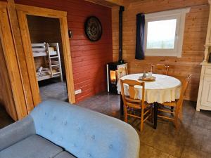 a living room with a table and a blue couch at La Belle brune, avec jacuzzi in Alincthun
