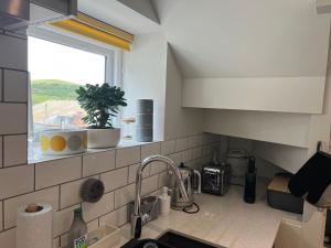 a kitchen counter with a sink and a window at The Boathouse, 18 Church Street in Salcombe