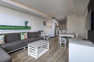 a living room with a couch and a table at The Breakers 310 in Durban +12 photos