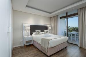 a bedroom with a large bed and a balcony at The Breakers 310 in Durban