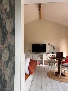a living room with a table and a tv at Le Bulloire in Montlouis-sur-Loire