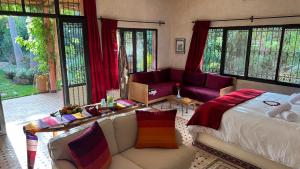 a bedroom with a bed and a couch at Suite de luxe - Dar Tidyan Maison d'Hôte - Ourika in Igzi Ou Fella +20 photos