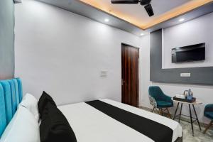 a bedroom with a bed and a tv on the wall at Hotel O The smart haven in Ghaziabad