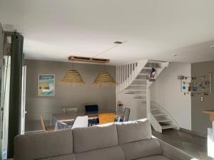 a living room with a couch and a staircase at La Petite Villa du Soleil in Lavalette