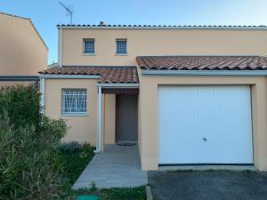 a white garage door on the side of a house at La Petite Villa du Soleil in Lavalette