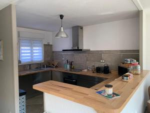 a kitchen with a wooden counter top in a room at La Petite Villa du Soleil in Lavalette