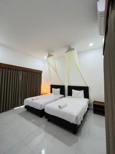 two beds in a room with two beds sidx sidx sidx sidx at parida bungalow in Gili Islands