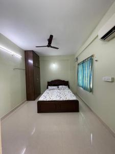 a bedroom with a bed and a ceiling fan at Brownie Paradise in Puttaparthi