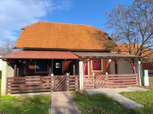 a small house with a fence and a red roof at Apartma Dian in Mostec +7 photos