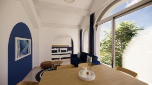 a dining room with a table and a large window at Villa Onyra - Studios, Suites & Villa in Saint-Cyr-sur-Mer