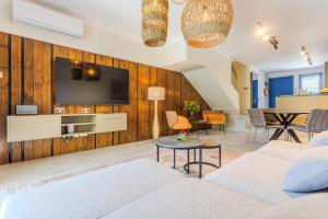 a living room with a couch and a tv at All Seasons Boutique Townhouse in Paphos City