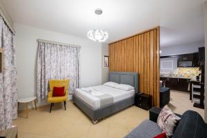 a bedroom with a bed and a yellow chair at Vila del Mar in Ksamil