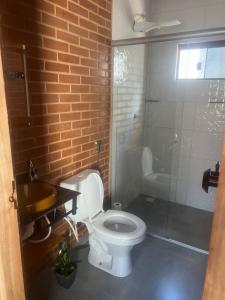 a bathroom with a toilet and a sink and a shower at Flats Ribeiro in Alto Paraíso de Goiás +1 photo