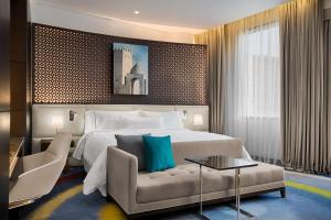 una habitación de hotel con una cama y un sofá en The Westin Doha Hotel & Spa, en Doha