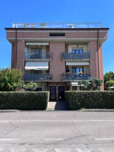 a red brick building with a balcony and bushes at La finestra su Assisi in Bastia Umbra