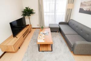 a living room with a couch and a television at GLOU Shibuya House - A Private House in Tokyo Shinjuku & Shibuya Area in Tokyo
