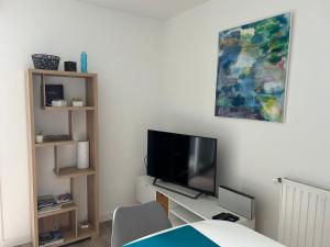 a living room with a tv and a bed at Appartement port du Crouesty avec terrasse et piscine in Arzon