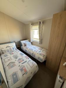 a bedroom with two beds and a window at 36 Lighthouse View in Lossiemouth +17 photos