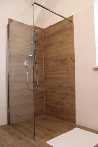 a shower stall with a wooden wall at Apartment Peer  +25 photos