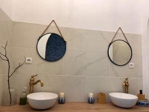a bathroom with two sinks and mirrors on the wall at Maison Gabriel in Lamastre +16 photos