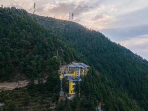 a building on the side of a mountain at The Hosteller Khajjiar in Khajjiar 
