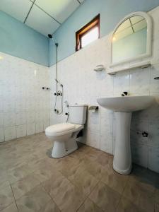 a bathroom with a toilet and a sink at Vinka Place Arugambay in Arugam Bay