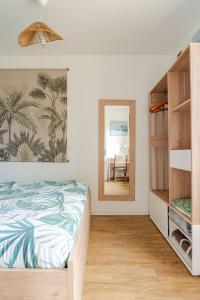 a bedroom with a bed and a mirror at "Escapade Nature" 1 place de parking et jardin paysager by Art De Voyager in Étretat