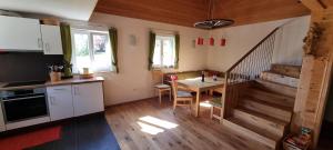 a kitchen and dining room with a table and a staircase at Ferienhaus Rain in Innerlaterns