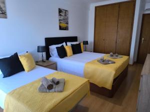 a bedroom with two beds with towels on them at Santa Rita Guest House in Olhão