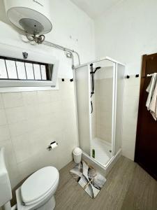 a white bathroom with a shower and a toilet at Casa Nala Costa Rei in Costa Rei
