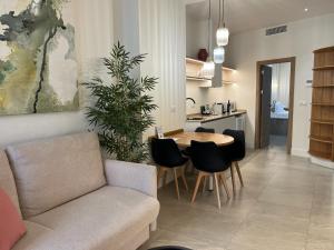 a living room with a couch and a table and chairs at Reina Victoria El Mercado in Alicante