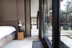 a bedroom with a bed and a glass door at Stalen Boshuis by Droomvilla in Oosterhout +34 photos