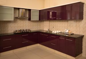 a kitchen with dark brown cabinets and a sink at Benaka Suites in Bangalore