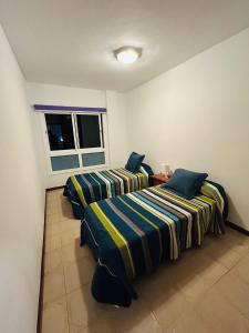 due letti in una stanza con finestra di Casa Suami a Puerto de la Cruz