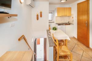 een keuken met een tafel en stoelen in een kamer bij Studio Apartment Tea in Baška