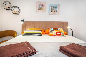 een slaapkamer met een bed met kleurrijke kussens bij Studio Apartment Tea in Baška