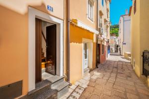 een steegje met een deur in een gebouw bij Studio Apartment Tea in Baška