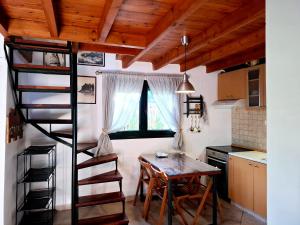 a kitchen with a spiral staircase and a table in a room at La casa di Kapo in Syvota
