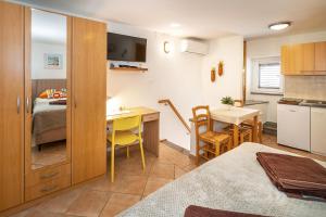 een kleine kamer met een keuken en een slaapkamer bij Studio Apartment Tea in Baška +7 foto's