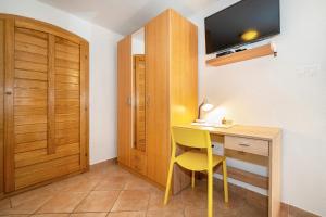 een kleine kamer met een bureau en een gele stoel bij Studio Apartment Tea in Baška