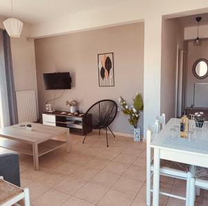 a living room with a table and a tv at Rosa Viola in Corfu