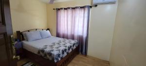 a small bedroom with a bed and a window at Lord's Hands Guesthouse Hotel in Winneba