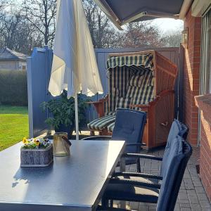 a table and chairs with an umbrella on a patio at Ferienhaus Sophie in Diekhusen-Fahrstedt