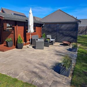 a patio with chairs and an umbrella in a yard at Ferienhaus Sophie in Diekhusen-Fahrstedt +17 photos