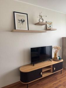 a flat screen tv sitting on top of a wooden entertainment center at Mulla Apartment in Haapsalu