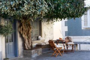 a table and chairs next to a building with a tree at Casa Degrassi - Main square - Seaview in Vrsar
