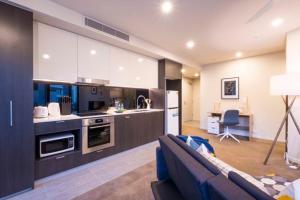 sala de estar con sofá azul en la cocina en KozyGuru | Brisbane CBD | 1 Bed APT | Spire, en Brisbane
