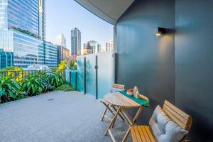 balcón con mesa, banco y vistas en KozyGuru | Brisbane CBD | 1 Bed APT | Spire, en Brisbane